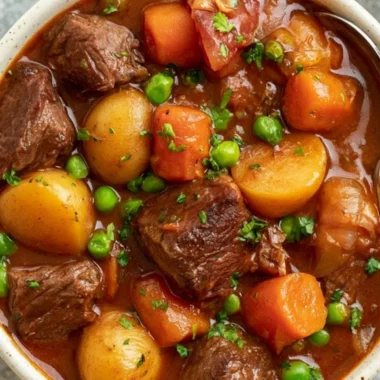 Slow cooker beef stew in a rustic bowl, garnished with herbs