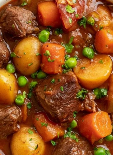 Slow cooker beef stew in a rustic bowl, garnished with herbs