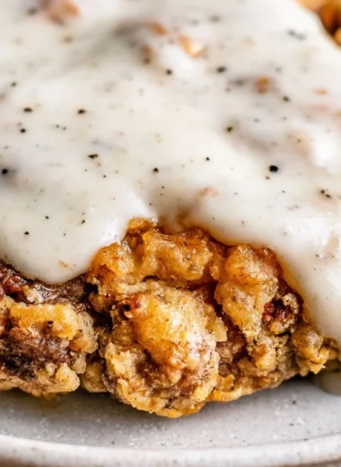 Delicious chicken fried steak served with creamy gravy and side dishes.