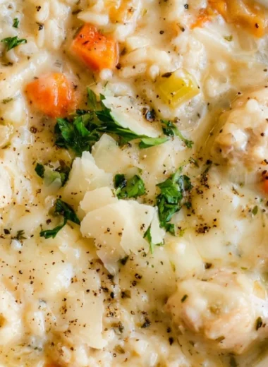 Delicious creamy chicken and rice soup in a bowl with fresh herbs
