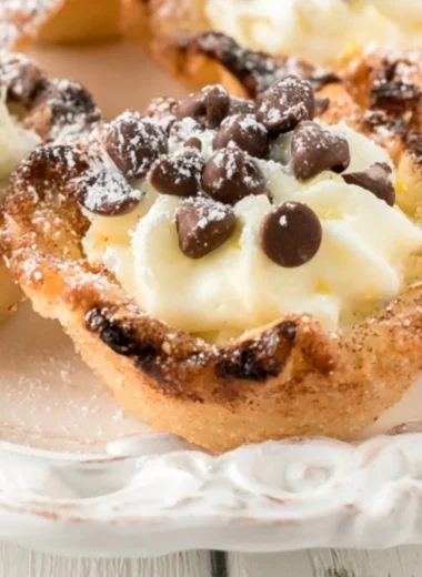 Delicious creamy mini cannoli cups topped with chocolate and powdered sugar