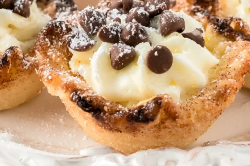 Delicious creamy mini cannoli cups topped with chocolate and powdered sugar