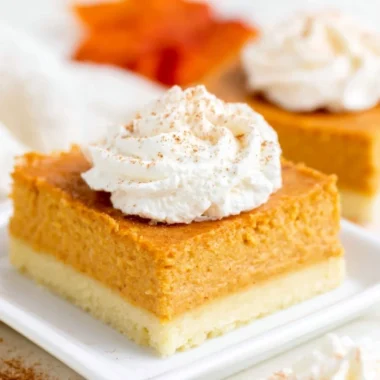 Delicious pumpkin pie bars on a plate with a buttery shortbread crust.