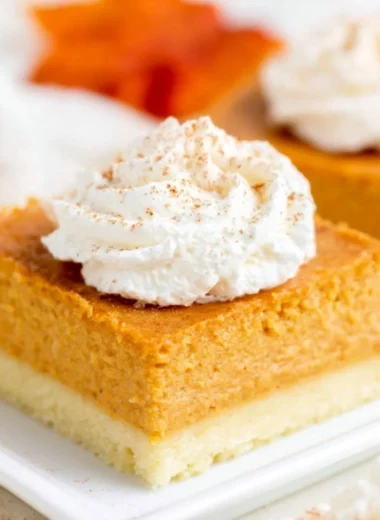 Delicious pumpkin pie bars on a plate with a buttery shortbread crust.