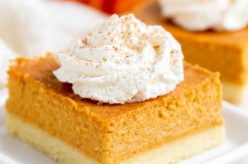 Delicious pumpkin pie bars on a plate with a buttery shortbread crust.
