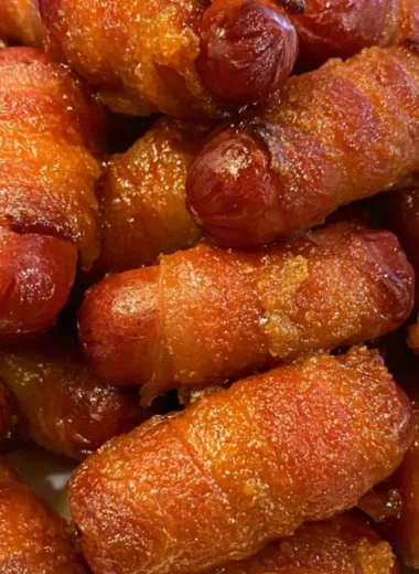 Bacon wrapped little smokies served on a platter with dipping sauce.