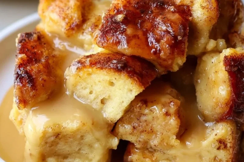 Delicious bread pudding drizzled with vanilla caramel sauce on a white plate