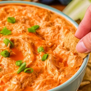 Buffalo Chicken Dip served in a bowl with tortilla chips on the side.