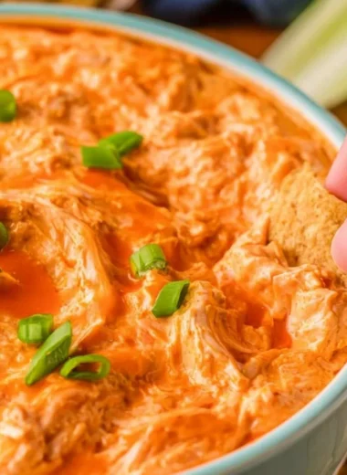 Buffalo Chicken Dip served in a bowl with tortilla chips on the side.