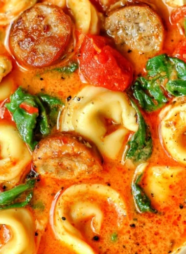 Bowl of healthy tortellini soup with vegetables and herbs