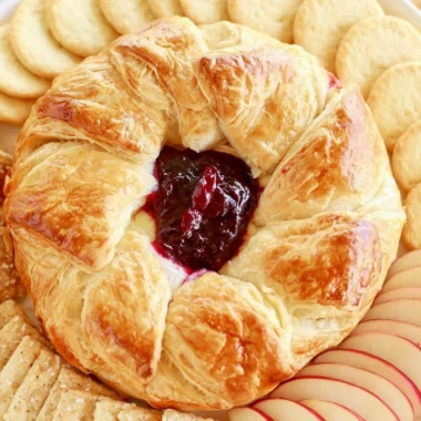 Delicious baked brie in puff pastry served with fruits and nuts