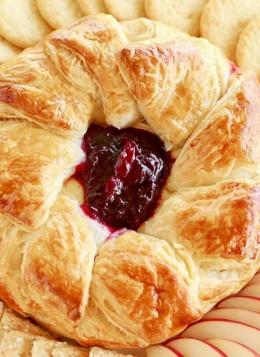 Delicious baked brie in puff pastry served with fruits and nuts