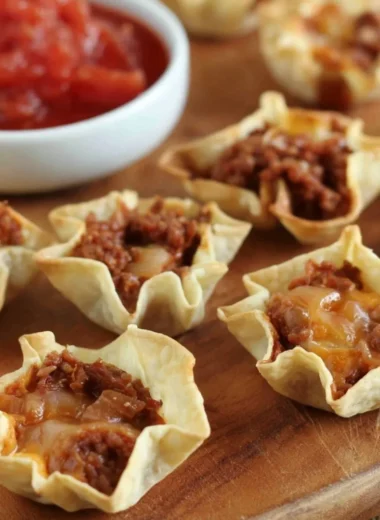 Delicious tortilla nacho cups filled with toppings, ready to be enjoyed.