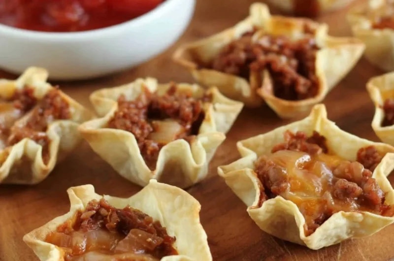 Delicious tortilla nacho cups filled with toppings, ready to be enjoyed.