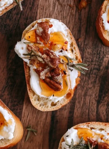 Delicious whipped feta crostini drizzled with hot honey served on a rustic platter.